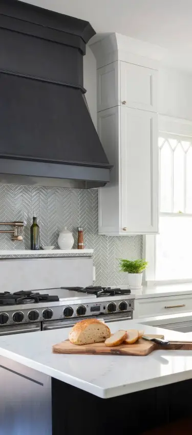 remodeled kitchen with black range hood and tile backsplash
