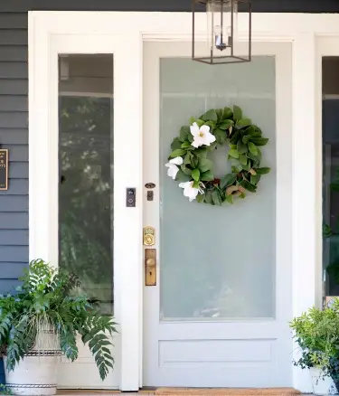 Front door with frosted glass and a floral wreath
