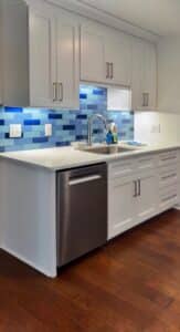 Kitchen remodel with a tiled backsplash in various shades of blue