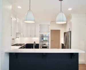 Kicthen remdoel with white marble countertops and blue shiplap breakfast bar. Peninsula style counter layout.