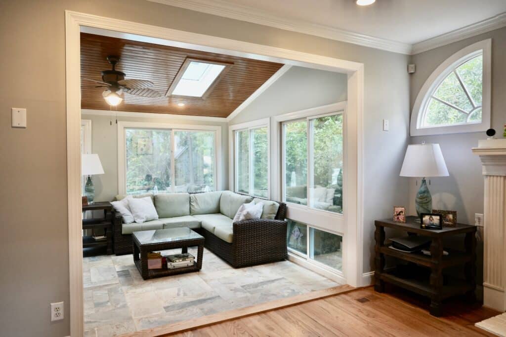 Sunroom addition with a fan and skylights and gray tiled flooring